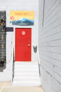 Bright red entrance door to Shades Brewing