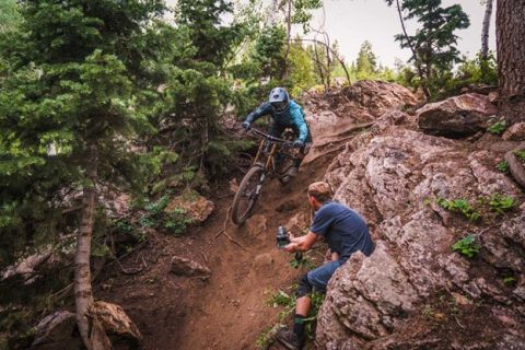 A mountain biker rips though a technical rock garden at Deer Valley