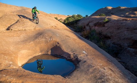 A mountain biker rides slickrock terrain in Moab