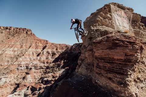 A competitor drops off a cliff on his bike at Red Bull Rampage
