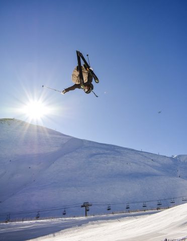 Skier in Utah, hitting the jumps at a Utah Ski resort terrain park. Skiing terrain parks in Park City Utah. Park City Utah skiing.