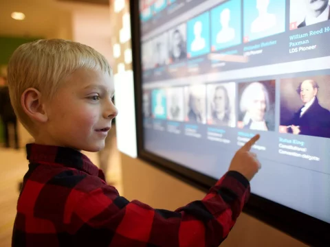 A young boy interacts with the touchscreen displays at the family history library's discovery center.