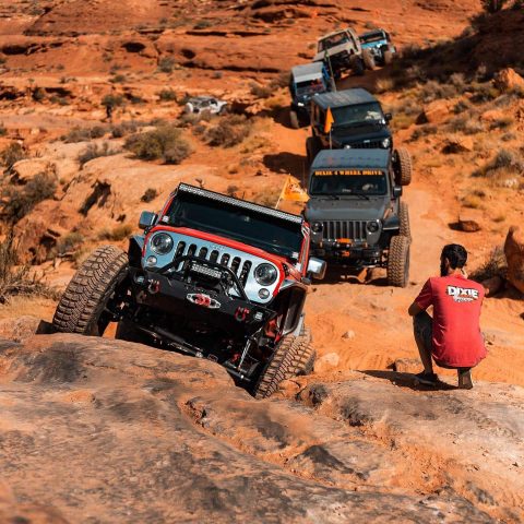 A line of Jeeps and off-road vehicles navigating a steep, rocky trail, highlighting popular motorsports and outdoor activities near Salt Lake City.
