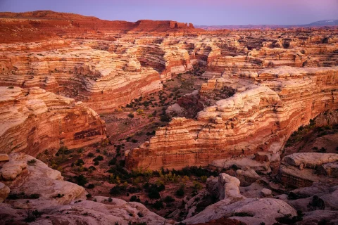 maze shapped mountainds with a purple sky at sundown 