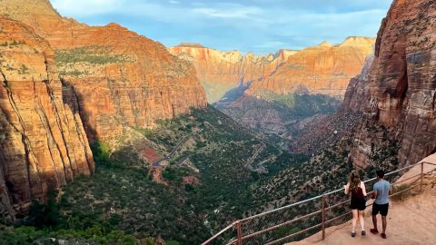 two people overlooking the canyon followed by a trail behind them