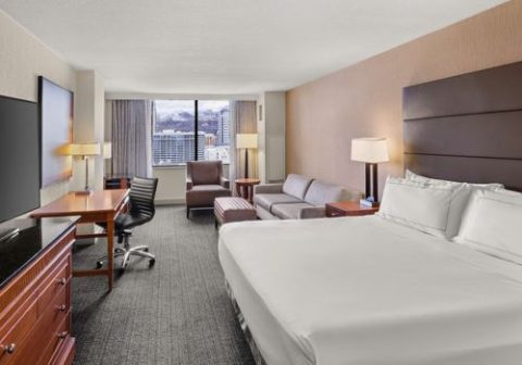 Hilton Salt Lake City Center hotel room with work desk, seating area, and downtown views for business travelers comparing Salt Lake City hotels