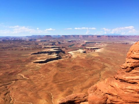 ariel view of orange rocks and mountains with clear blue skies