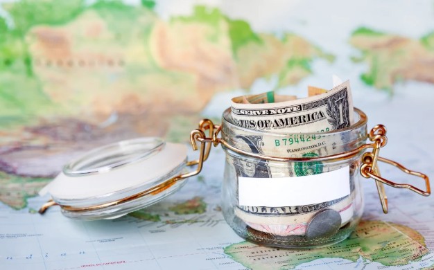 Travel savings jar with cash on a map, representing Salt Lake City hotel deals and budget-friendly trip planning